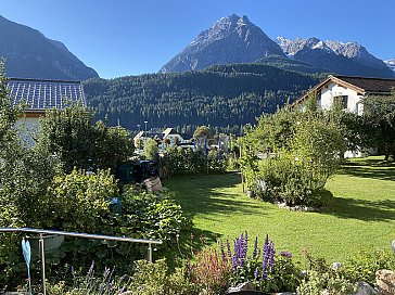 Ferienwohnung in Scuol - Aussicht, Garten ab Terrasse und Eingang.